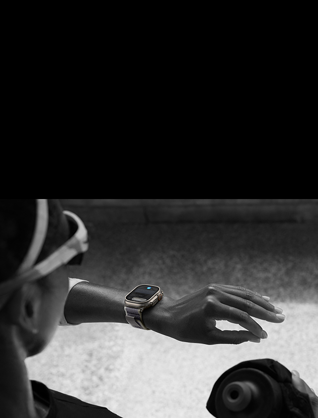 Sol bileğindeki Apple Watch Ultra 2’ye bakarken işaret parmağı ve baş parmağını birbirine iki kez dokundurarak çift dokunuş hareketi yapan koşucu