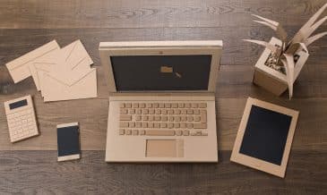 Creative eco-friendly office desk items, laptop, tablet and smartphone handmade using recycled cardboard, top view